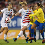 Sam Mewis heading the ball against the opponent