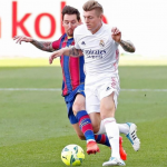 Toni Kroos heading the ball against the opponent, Lionel Messi